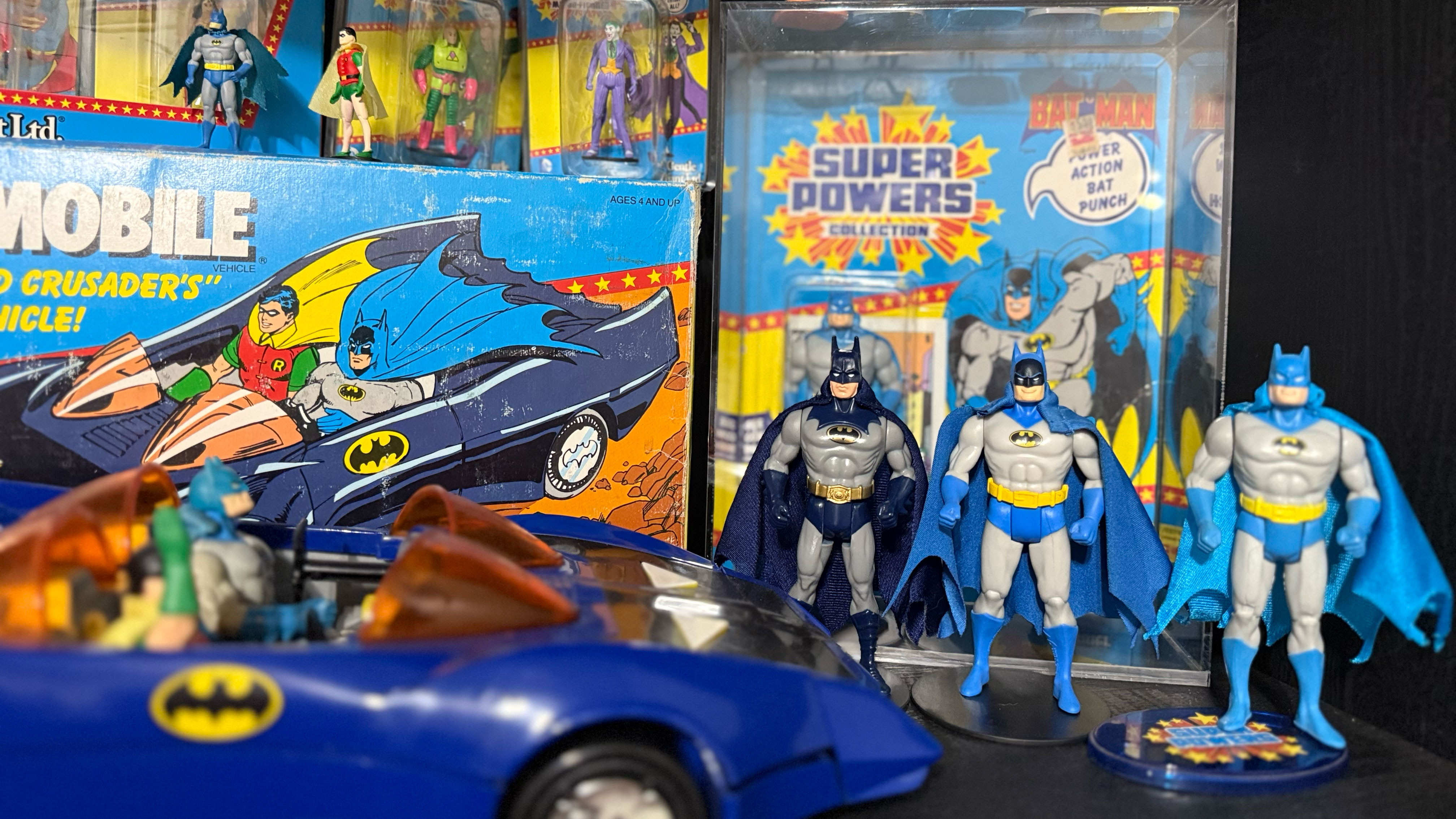 Photo of Various Super Powers Batman and Batmobile on shelf.